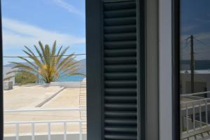una ventana con vistas a una palmera en Esperos Seaside Suite in Adamas, Milos en Adamas