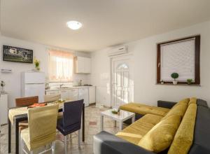 a living room with a couch and a table and a kitchen at Apartman Mare Vir in Vir