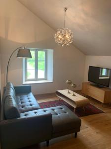 a living room with a couch and a television at Maison SANS SOUCI in Lajoux