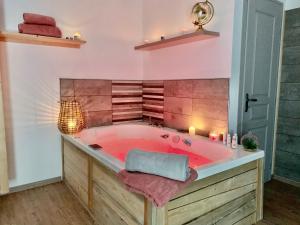 a hot tub in a bathroom with pink walls at Le long du Verdon in Castellane