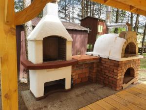 a outdoor pizza oven sitting on top of a deck at Domek nad jeziorem Rumian in Rybno
