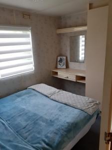 a bedroom with a blue bed and a mirror at Wiklinowa Zatoka in Wetlina