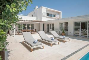 a patio with two lounge chairs in front of a house at Villa Linda in Aldeia do Meco