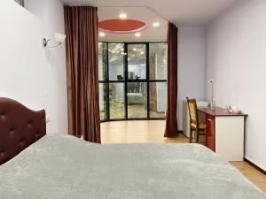 a bedroom with a bed and a desk and a window at Lot Hotel in Ijevan