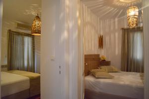 a bedroom with two beds and two chandeliers at Esperos Seaside Suite in Adamas, Milos in Adamas