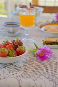a table with a plate of strawberries and a glass of orange juice at Esperos Seaside Suite in Adamas, Milos in Adamas