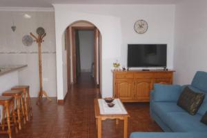 a living room with a blue couch and a tv at Apartamento La Ubilla in Famara