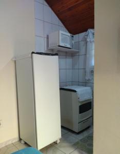 a kitchen with a refrigerator and a microwave at Chalé suíte com ar em Resende in Resende
