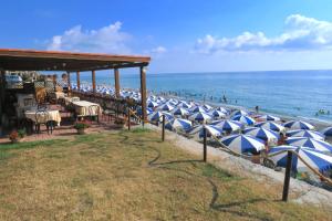 a row of blue and white umbrellas on a beach at Hotel Club Residence Martinica in Bonifati