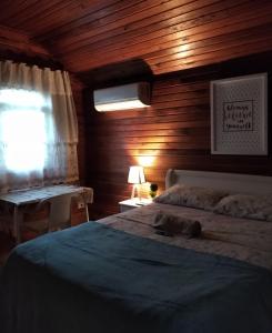 1 dormitorio con 1 cama con pared de madera en Chalé suíte com ar em Resende en Resende