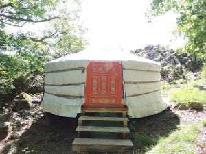 a yurt with a red door and some stairs at Yourte mongole in Mont-Roc