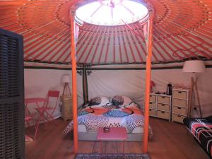 zwei Personen, die in einem Bett mit Baldachin in einem Zimmer schlafen in der Unterkunft Yourte mongole in Mont-Roc