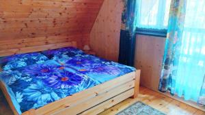 a bedroom with a bed with blue flowers on it at Chata Rynartice 7 in Jetřichovice