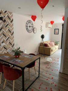 a living room with a table and red hearts on the wall at Sylina Spa avec Jacuzzi Privé in Villeblevin