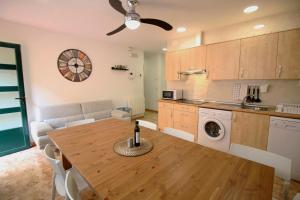 a kitchen and living room with a wooden table and a dining room at Aralso Santa Isabel in Segovia