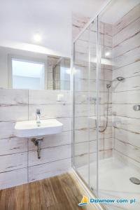 a bathroom with a sink and a shower at MK Kamiński in Dziwnów