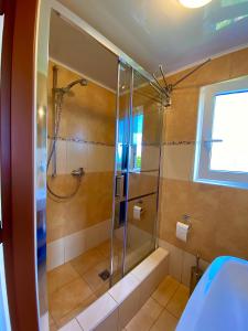 W łazience znajduje się prysznic ze szklanymi drzwiami. w obiekcie Rodinná Chatka Mehes w mieście Doksy