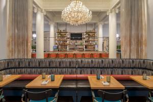 バークレーにあるホテル シャタック プラザの木製テーブルとシャンデリアのあるレストラン