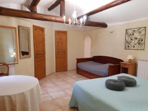 a bedroom with a bed and a couch in a room at Chambres & Tables d'hôtes Moulin de Lavon in Gargas