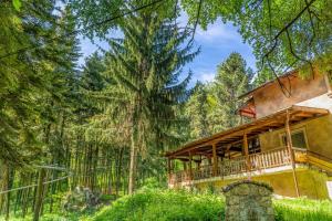 ein Haus im Wald mit einer Terrasse in der Unterkunft Къща за гости - Крушун in Krushuna