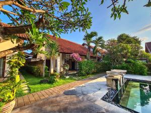 an exterior view of a house with a swimming pool at Sayang Taman Villas in Sanur