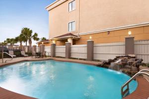 a large swimming pool in front of a building at Days Inn & Suites by Wyndham Houston Hobby Airport in Houston