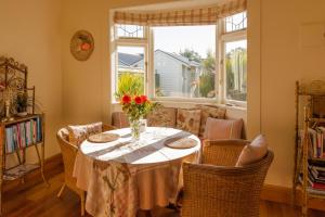 a dining room table with chairs and a vase of flowers at Elliott Street Gem in Nelson +11 photos