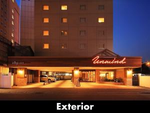 an exterior view of a hotel with a neon sign at UNWIND HOTEL&BAR SAPPORO in Sapporo