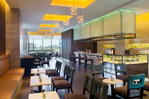 a restaurant with tables and chairs and a bar at Holiday Inn Nanyang by IHG in Nanyang