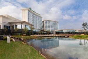 um edifício de hotel com um lago em frente em Holiday Inn Nanyang, an IHG Hotel em Nanyang