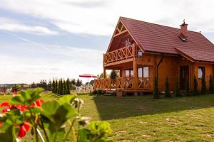 a large wooden house with a large deck at Mazurska Przystań in Giżycko