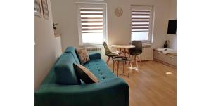 a living room with a blue couch and a table at Magnolija in Široki Brijeg