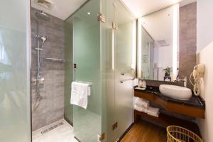a bathroom with a glass shower and a sink at Four Seasons Are Picturesque Guesthouse in Zhangjiajie