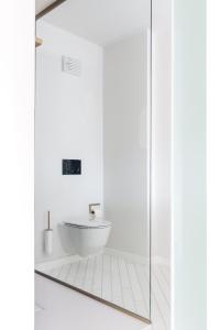 a white bathroom with a sink and a glass shower door at Kai 36 - Hotel zwischen Fels und Fluss in Graz