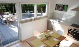 eine kleine Küche mit einem Tisch und eine Küche mit einer Terrasse in der Unterkunft Ferienhaus Sunny in Gengenbach