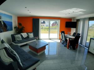 una sala de estar con un sofá y una mesa en Wellenreiter 1, en Breege