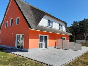 una casa roja con techo negro en Wellenreiter 1, en Breege