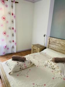 two twin beds in a bedroom with a curtain at Chambres d'hôtes l'Orchidée Rose in Salazie