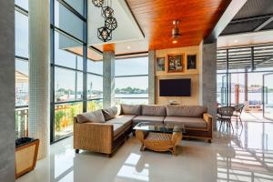 a living room with a couch and a tv at The Blue C Donsak in Surat Thani