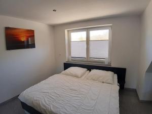 Un dormitorio con una cama grande y una ventana en Wellenreiter 1, en Breege