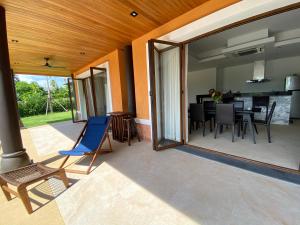 een terras met een blauwe stoel en een eetkamer bij Villa Tango Victoria Resort, Koh Yao Noi in Ko Yao Noi