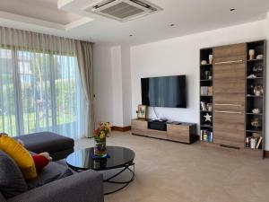 een woonkamer met een bank en een tv bij Villa Tango Victoria Resort, Koh Yao Noi in Ko Yao Noi