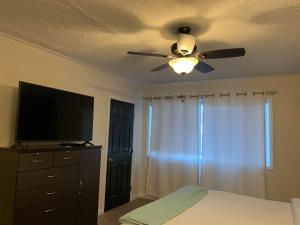 a bedroom with a ceiling fan and a television at The Wing at Kingston East in Rexburg