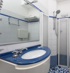 Un baño con un lavabo azul y una ducha. en Hotel New Castle, en Cesenatico 31 fotos más
