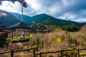 a person sitting on a rock in a gazebo overlooking a mountain at Μαγεμένο Βουνό in Karpenisi