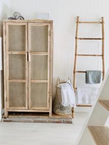 a wooden cabinet in a room with a ladder at ELSK Cottage in Zandvoort