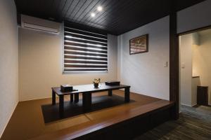 einen Tisch in einem Zimmer mit Fenster in der Unterkunft GRAND BASE Crane in Fukuoka