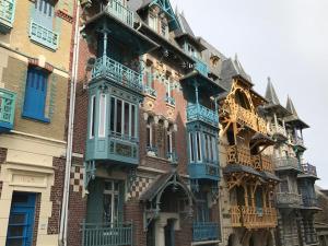 a tall brick building with blue windows and balconies at MAISON A LA CAMPAGNE PROCHE BAIE DE SOMME in Arrest +17 photos