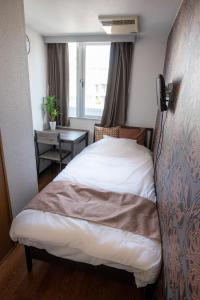sypialnia z łóżkiem, oknem i stołem w obiekcie Vail sta Takenotsuka w Tokio
