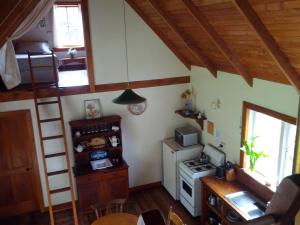 a small kitchen with a stove and a refrigerator at The Innlet, Country Apartments and Cottages in Collingwood